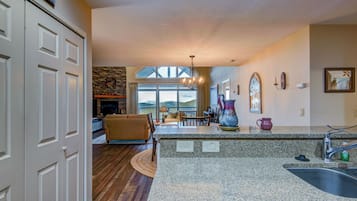 A spacious living area with a fireplace, a dining table, and a view of the outdoors.