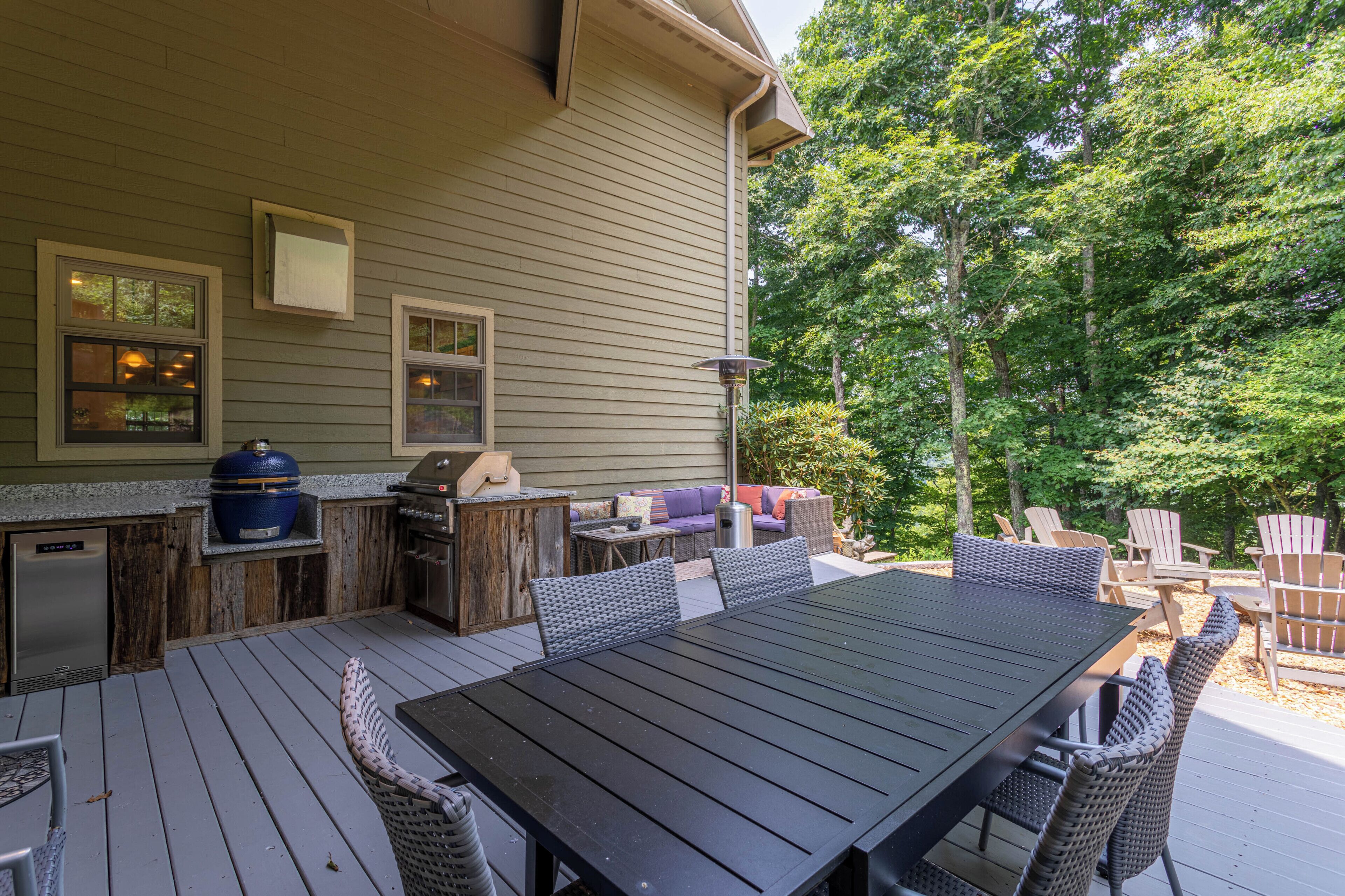 Eine Terrassengaststätte mit Esstisch, Stühlen, Grill und eingebautem Ofen.