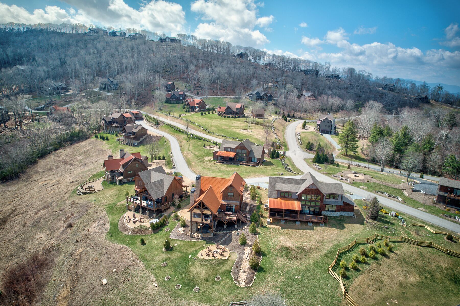 A residential area with houses, roads, and a hilly landscape.