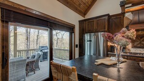 Une cuisine spacieuse dotée d’un grand îlot central, de meubles en bois et offrant une vue sur l’extérieur.