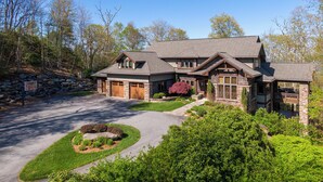A two-story house with a stone facade, a garage, and a landscaped front yard. - Horizons Edge (Boone)