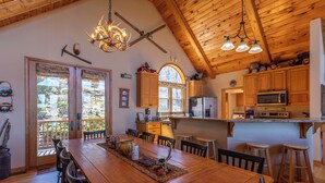 A spacious kitchen with wooden cabinets, a large island, and a dining area with a long wooden table.