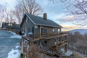 A two-story lodge with a balcony and a stone chimney. - Blue Ridge Vista (Banner Elk)