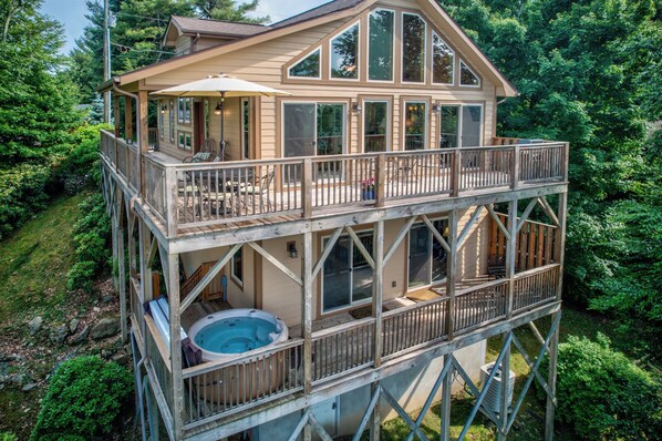 A two-story wooden cabin with a balcony and a hot tub. - 1 Beautiful View (Blowing Rock)