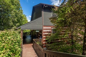 A wooden deck leading to a building with a sloped roof and a covered entrance. - Amen Corner Close to Boone! Hot Tub, Pet Friendly, Ping Pong, Foosball, Mountain Views (Vilas)
