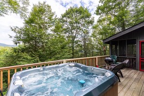 A hot tub on a wooden deck with a view of trees and mountains. - Scarborough Fair (Banner Elk)