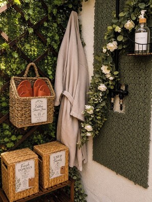 A wicker basket with sandals, a towel, and boxes of used towels. - The Green Haus-Tiny Home with private Jacuzzi (Buena Park)