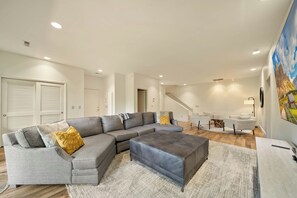 A modern living room with a sectional sofa, ottoman, and a staircase leading to another level. - Banner Elk Valley Overlook (Banner Elk)