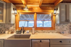 A kitchen with a large window, wooden ceiling beams, and a Bosch dishwasher. - St Johns Ridge (Sugar Grove)