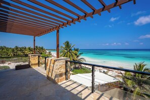 Ein Balkon mit Blick auf Strand und Meer.