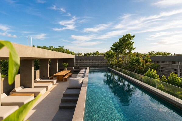 A rooftop pool with a clear blue sky, surrounded by modern outdoor seating and greenery. - Romantic Jungle Studio, Rooftop Pool & Lounge Fast WIFI/AC in Tulum (Tulum)