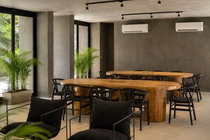 A conference room with a large wooden table, black chairs, and potted plants. - Romantic Jungle Studio, Rooftop Pool & Lounge Fast WIFI/AC in Tulum (Tulum)