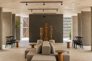 A modern interior with a sofa, two wooden tables, and black chairs. - Romantic Jungle Studio, Rooftop Pool & Lounge Fast WIFI/AC in Tulum (Tulum)