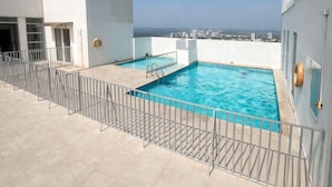 Una piscina en la azotea con vistas despejadas al horizonte de la ciudad.