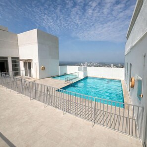 Una piscina en la azotea con vistas despejadas al horizonte de la ciudad.