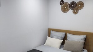 A bedroom with a bed, pillows, a headboard, and wall decor. - Charming full T1 (Zillisheim)