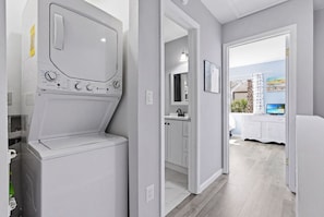 Ein Waschraum mit Waschmaschine, Spüle und Schrank.