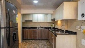 A kitchen with a refrigerator, stove, sink, and a water heater. - Suit Double 304 with Sale + Kitchen and Laundry (Bogotá)