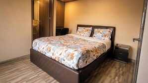 A bedroom with a bed, a nightstand, a wardrobe, and a bathroom door. - Suit Double 304 with Sale + Kitchen and Laundry (Bogotá)