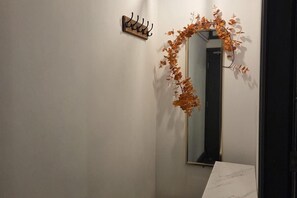 Ein Badezimmer mit Spiegel, Handtuchhalter und einer Zierpflanze.