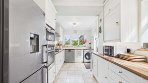 A modern kitchen with stainless steel appliances, a dishwasher, and a microwave. - Stylish Coastal Cottage in Gurnard, Dog Friendly Garden (Cowes)