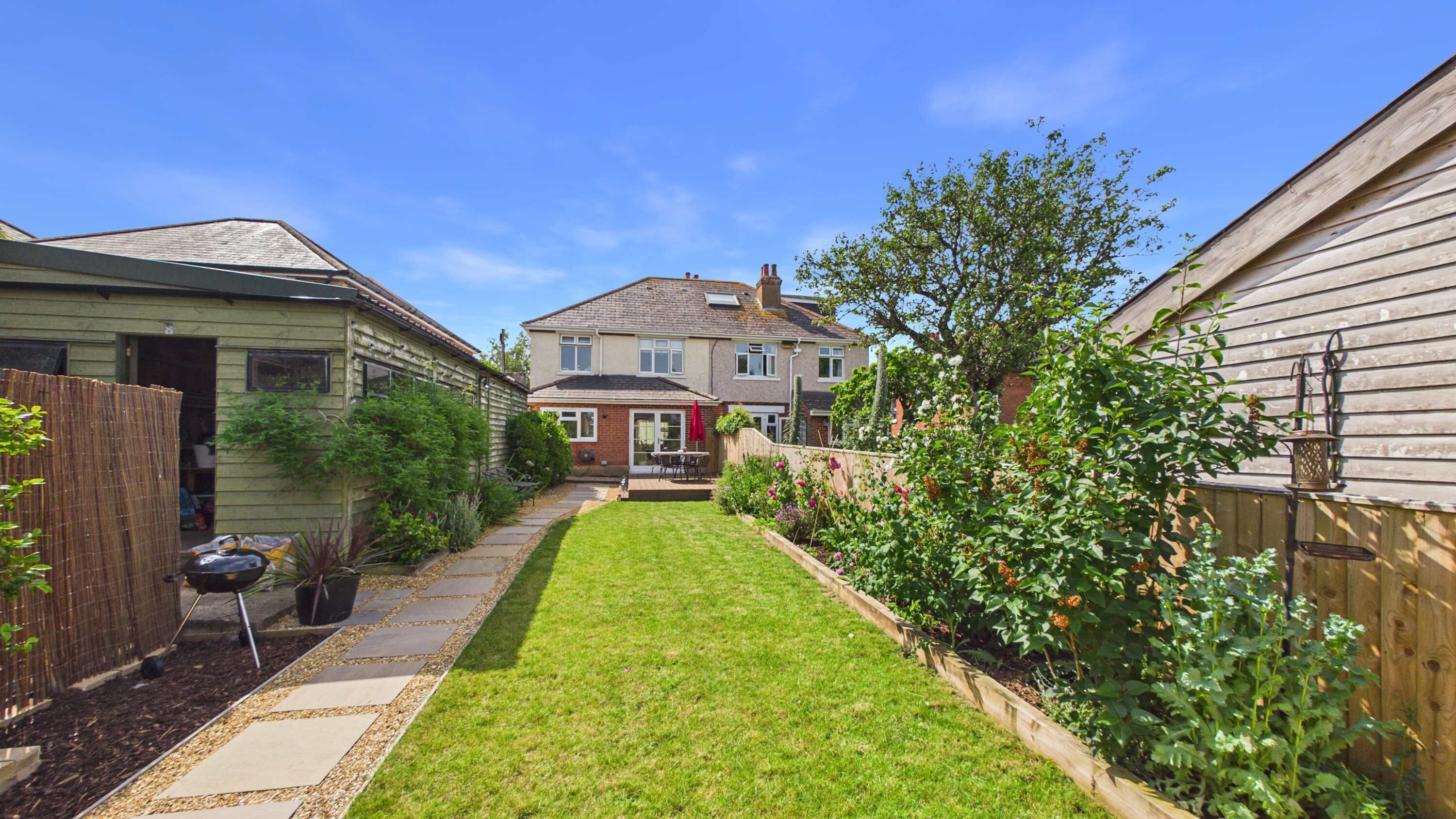 Landscaped garden with outdoor dining area and BBQ  