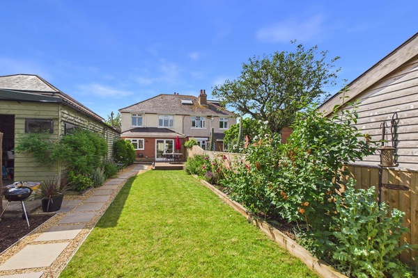 Landscaped garden with outdoor dining area and BBQ