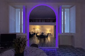 A modern interior with a dining area, kitchen, and a large arched doorway. - Shelter in Navona Designer loft in Piazza Navona (Roma)