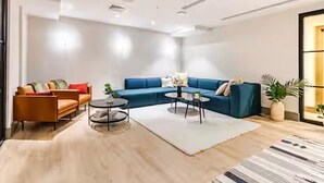 Ein modernes Wohnzimmer mit einem blauen Sofa, einem braunen Sofa und einem Couchtisch.