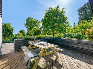 A wooden deck with a picnic table and a bench, surrounded by greenery and trees. - "Isalie" - 300m from the sea by Interhome (Ebeltoft)