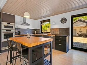 A modern kitchen with a wooden island, black cabinets, and a large window. - "Isalie" - 300m from the sea by Interhome (Ebeltoft)