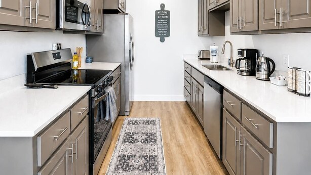Una cocina moderna con electrodomésticos de acero inoxidable, armarios de madera y una isla central.