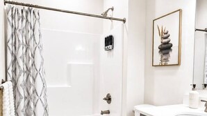 Un baño moderno con bañera, inodoro y tocador.