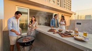 A rooftop bar with a grill, bar area, and dining space.