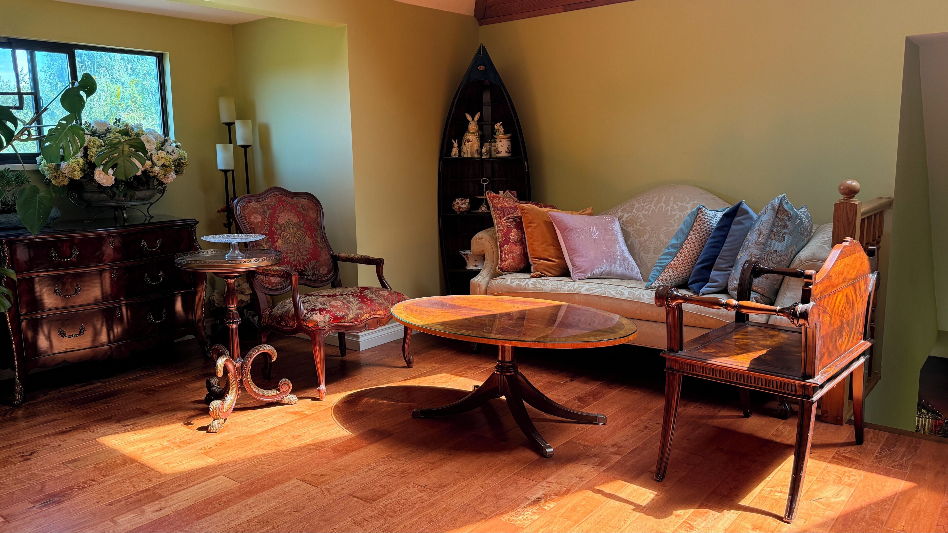 A living room with a sofa, armchairs, a coffee table, a wooden cabinet, and a decorative shelf.