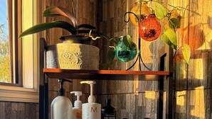 Une salle de bain avec un meuble-lavabo en bois, une baignoire et divers produits de toilette.