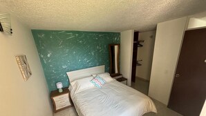 A bedroom with a bed, bedside table, nightstand, and a mirror. - Cozy, family and pet-friendly apartment, located right beside a beautiful park. (Bogotá)