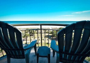 Zwei Adirondack-Stühle mit Blick auf einen Strand und den weiten Ozean.