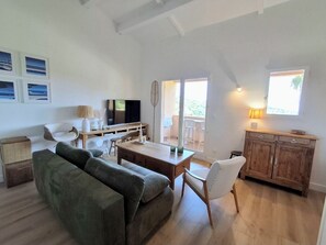 A spacious living area with a sofa, dining table, and wooden cabinets. - Cozy apartment with a view of the sea and the pool in a private residence. Pets Allowed (Roquebrune-sur-Argens)