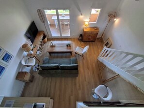 A spacious living area with a sofa, chairs, a dining table, and a TV. - Cozy apartment with a view of the sea and the pool in a private residence. Pets Allowed (Roquebrune-sur-Argens)
