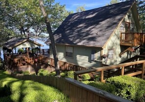 A two-story house with a deck and a small porch.