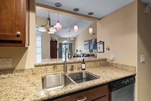 A kitchen with granite countertops, stainless steel sinks, and a dishwasher. - Luxury Resort Condo w/Pool, Spa, Gym & Pickleball 2b/2ba (Scottsdale)