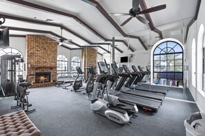 A gym with treadmills, ellipticals, and a brick fireplace. - Luxury Resort Condo w/Pool, Spa, Gym & Pickleball 2b/2ba (Scottsdale)