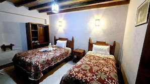 A room with two beds, a wardrobe, and a small table. - Hotel Plaza Baratillo (Guanajuato)