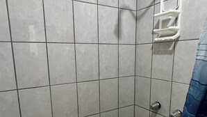A tiled shower stall with a showerhead, a grab bar, and a drain. - Cozy Rooms Rocky Point - Walk to Playa Hermosa (Puerto Penasco)