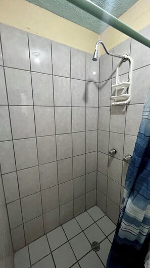 A tiled shower stall with a showerhead, a grab bar, and a drain. - Cozy Rooms Rocky Point - Walk to Playa Hermosa (Puerto Penasco)