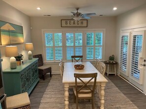 A dining area with a table, chairs, a ceiling fan, and a view through large windows. - Dog friendly| community pool | gym| kayak| bayside (Selbyville)