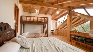 A wooden cabin bedroom with a bunk bed, a desk, and a view through a window. - Paseo del Llano Grand Cabañas (Mazamitla)