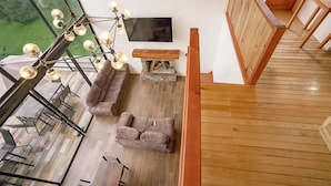 A modern living room with a sectional sofa, a wooden coffee table, and a large flat-screen TV. - Paseo del Llano Grand Cabañas (Mazamitla)