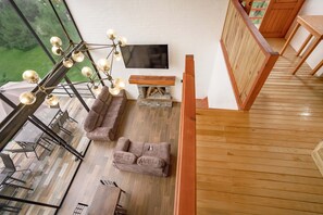 A modern living room with a sectional sofa, a wooden coffee table, and a large flat-screen TV. - Paseo del Llano Grand Cabañas (Mazamitla)